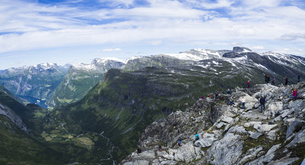 Fototapeta na wymiar Turistas contemplando las vistas de Geiranger desde el Mirador de Dalsnibba, en Noruega, en el verano de 2017