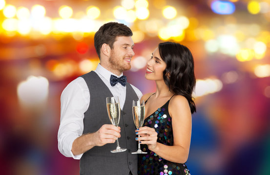 party, celebration and holidays concept - happy couple with glasses drinking non alcoholic champagne over night city lights background