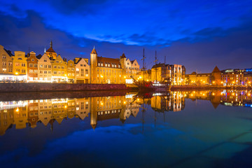 Fototapeta na wymiar Old town of Gdansk reflected in Motlawa river at dusk, Poland