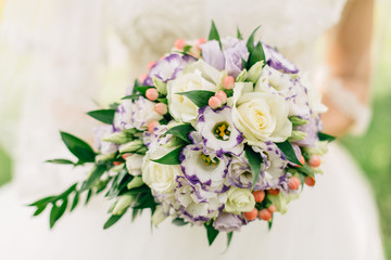 hands of bride with beautiful bouquet