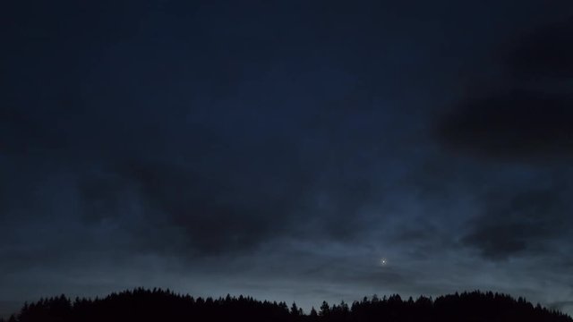 4K Time-Lapse. Espectacular paisaje con nubes pasando sobre una monta&ntilde;a por la noche a la luz de la luna.. Alemania