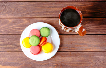 Colorful sweet macarons and hot drink.