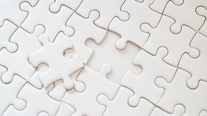 hand holding piece of white jig saw puzzle place to match or completing the final pazzle piece.Success,game,solve problem business concept.