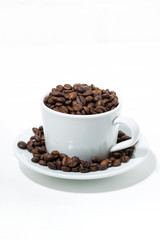 mug with coffee beans on white background, concept photo, vertical
