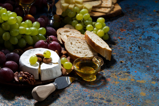 snacks, fruit and Camembert cheese on a dark background