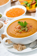 soup of pumpkin and lentils in a bowl, vertical closeup