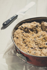 Coffee cake in a tin pan on white wooden table. Vertical.