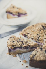 Tasty berries coffee cake on white wooden table. Vertical.