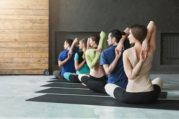Fototapeta na wymiar Young women and men in yoga class, relax meditation pose