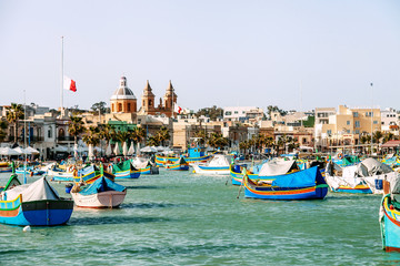 Marsaxlokk, Malta - March 31, 2018:  Famous multicolored fisherman's boats in Marsaxlokk - traditional fishing village, Malta