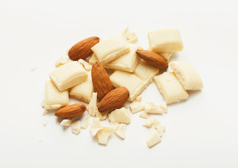 Broken white chocolate bar and almonds isolated