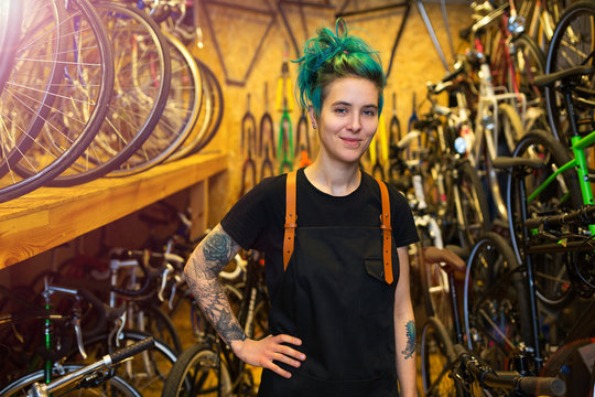 Confident young woman working in a bicycle repair shop
