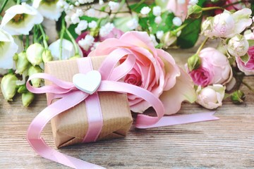 Obraz na płótnie Canvas Blumenstrauß mit Geschenk - Grußkarte - kleines Geschenkpäckchen mit Herz und rosa Schleife