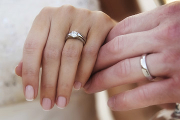 Couple holding hands showing rings