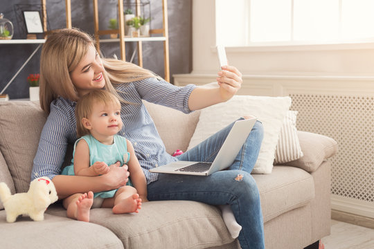 Young mother working and spending time with baby