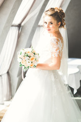 Naklejka premium Portrait of stunning bride with long hair posing with great bouquet
