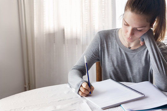 A Female Secondary School Student Doing Homework At Home.