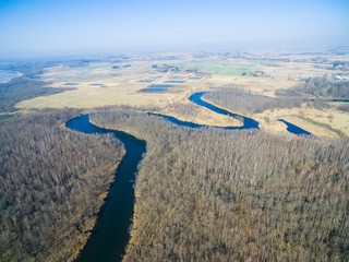 Meander of Wegorapa river flowing across wetlands during early spring season, Mazury, Poland