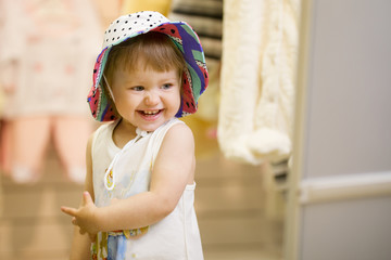 Portrait of happy little girl in the hat at the children's store