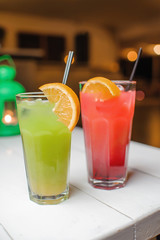 summer cool cocktail of green and red color with lemon and alcohol