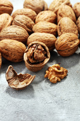 Walnut kernels and whole walnuts on rustic old table