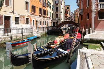 Fototapeta na wymiar Typical view of gondolas and boats on the canal of Venice. Sunny summer day