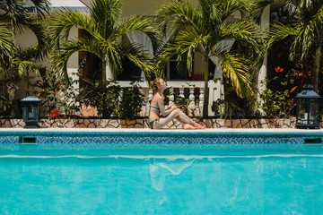 Eine junge Frau erholt sich am Pool 