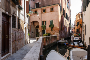 Typical view of gondolas and boats on the canal of Venice. Sunny summer day
