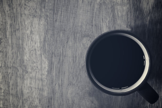 Black coffee on wooden table background. Top view. Free space for text.
