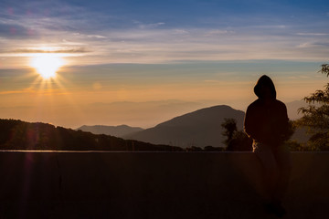 silhouette person feel with background sunrise at top moutain