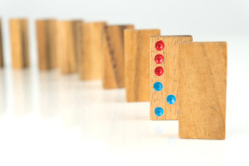 wooden dominoes standing in a row on white table