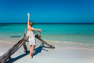 Eine junge Frau spaziert am Strand in der Karibik auf Jamaika
