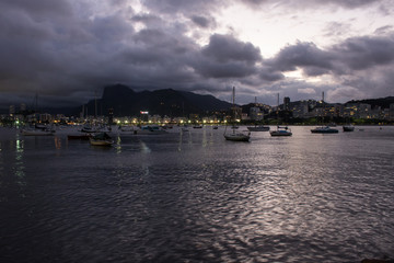 Obraz premium beautiful natural landscape of boats on lake in the early evening with buildings in the background on urca beach in the city of rio de janeiro 2018