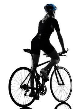 one caucasian cyclist woman cycling riding bicycle in silhouette isolated on white background rear view