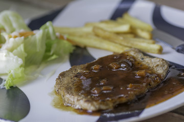 Pork steak in a plate at a restaurant.