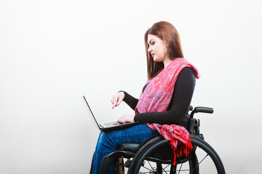 Young girl on wheelchair surfing web.
