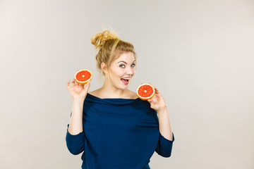 Happy smiling woman holding red grapefruit