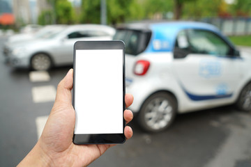 Man calls car with mobile phone APP in parking lot