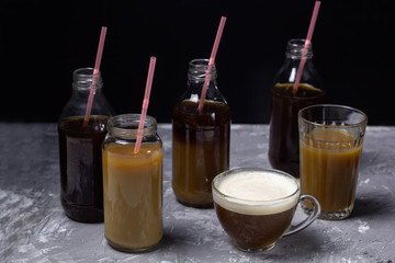 various of  coffee drinks in different cups and bottles dark background