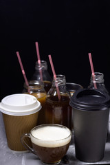 various of  coffee drinks in different cups and bottles dark background
