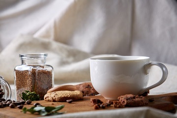 Breakfast background with mug of fresh coffee, homemade oatmeal cookies, grind coffee