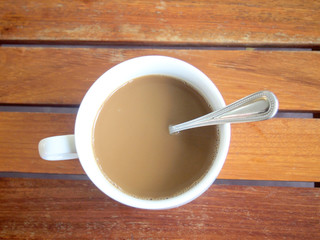 Cup of coffee on wooden table, top view
