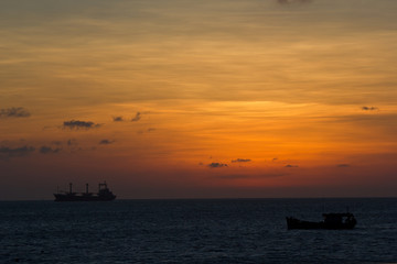 Sunset over the sea and a big ship