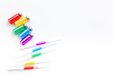 Syringe with colored drug. Injection concept on white background top view copy space