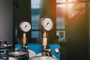 Closeup of manometer, measuring gas pressure. Pipes and valves at industrial plant.Pressure gauge, measuring instrument close up on oil and gas pipeline.