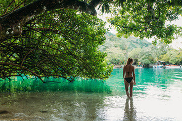 Eine junge Frau in Blue lagoon auf Jamaika