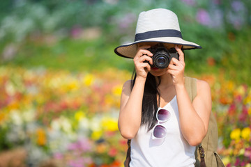 Happy female tourist to travel in wild trip flower garden and photography during vacation.Travel hiking.