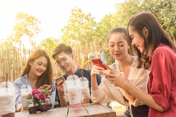 Group of teenager adding friend play social media with smartphone together in coffee shop 