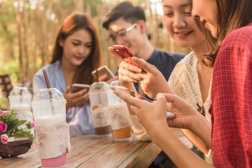 Group of teenager adding friend play social media with smartphone together in coffee shop