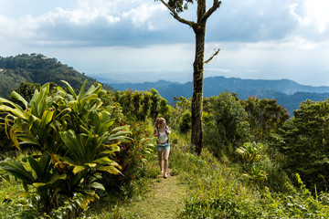 Fototapeta premium Junge Frau wandert in den Bergen in der Karibik auf Jamaika